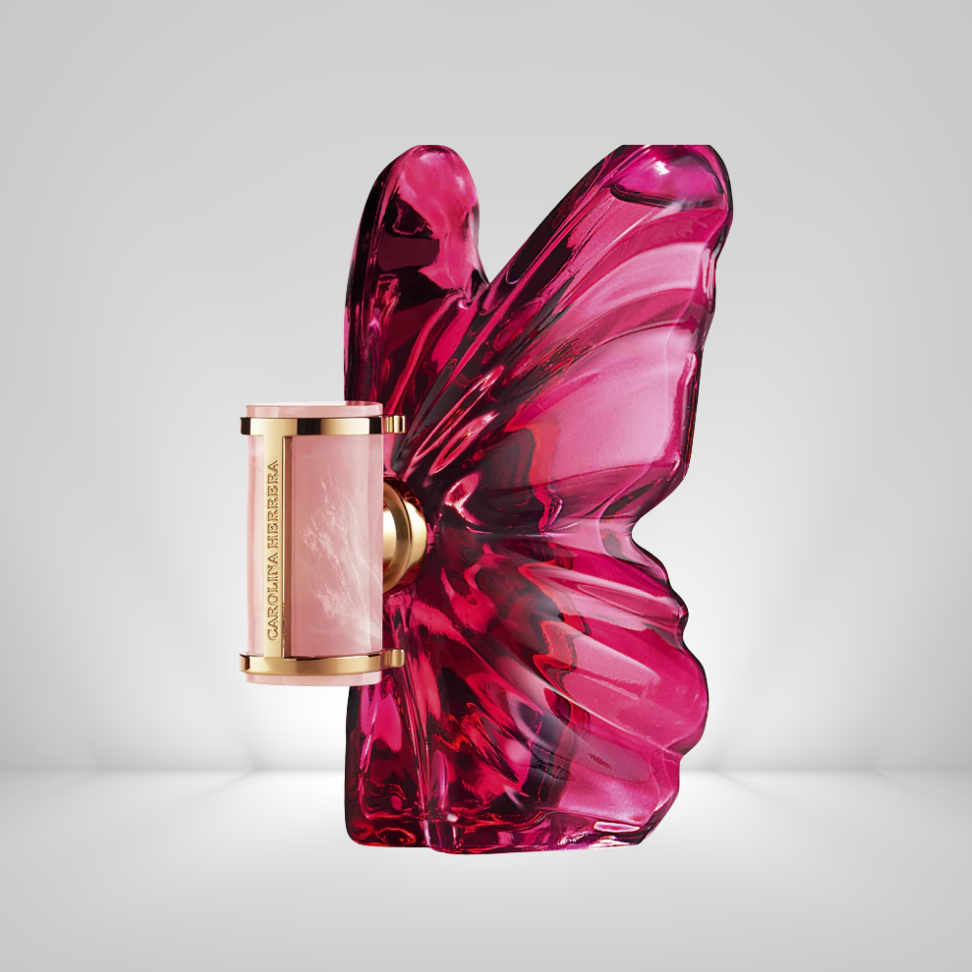Carolina Herrera La Bomba Eau de Parfum Pink butterfly-shaped perfume bottle with gold cap on a light gray background